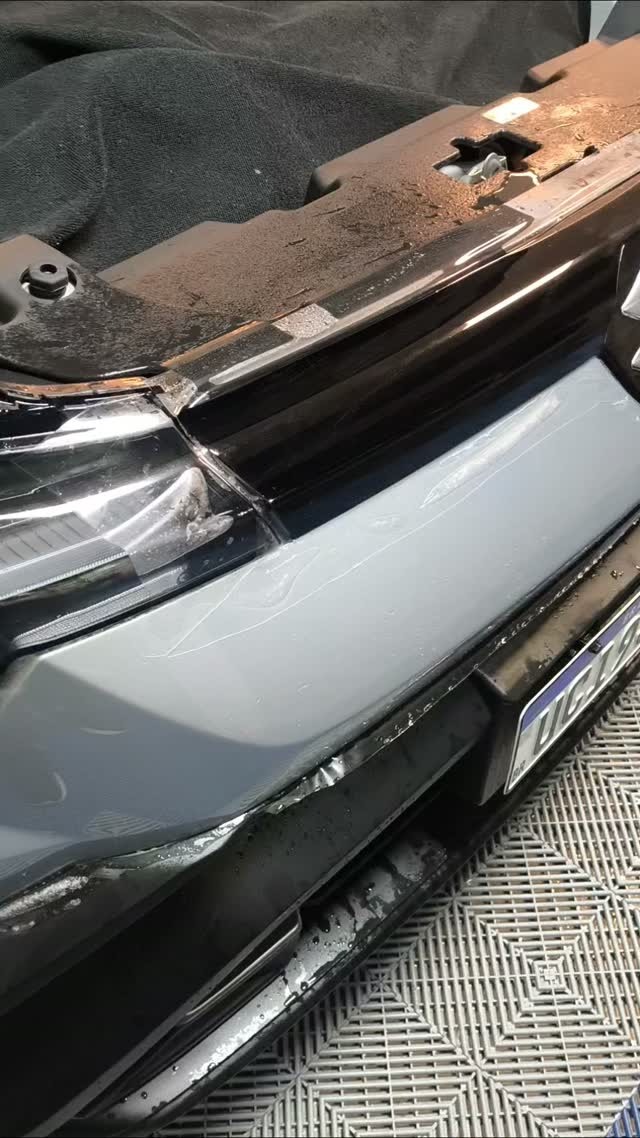 Detalhe de aplicação de película automotiva em para-choque de veículo